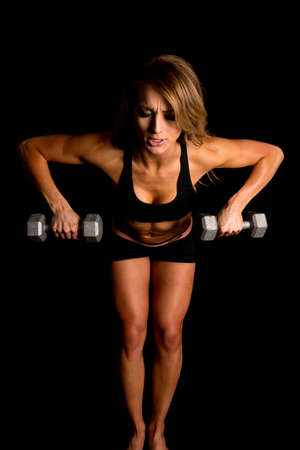 A fit woman leaning over and doing a row to work out her body.の写真素材
