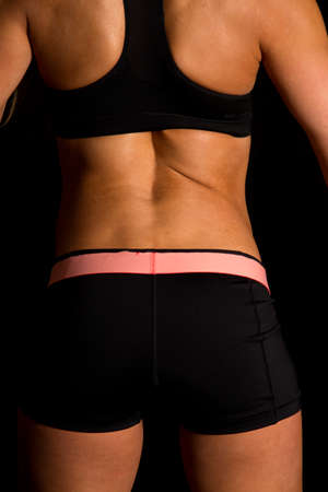 a fit woman close up with her back to the camera.