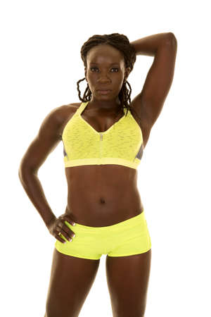 An African American woman in her fitness clothing flexing her body.の写真素材