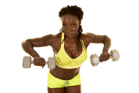 A woman in her fitness clothing working out her arms with weights.の写真素材