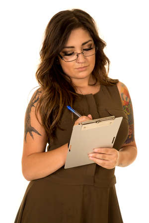 A business woman in her brown dress, taking notes with tattoos on her body.の写真素材