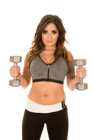 A woman in her fitness clothing, working out with her weights.の写真素材