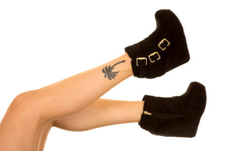 A woman in her black shoes, with a tattoo on her ankle.の写真素材