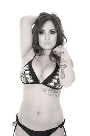 a woman looking in her bikini with her tattoos showing on her body.の写真素材