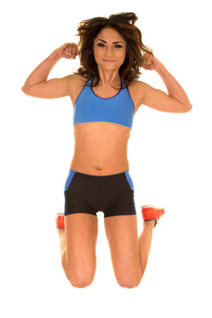 a woman in her fitness clothing, jumping in the air.の写真素材
