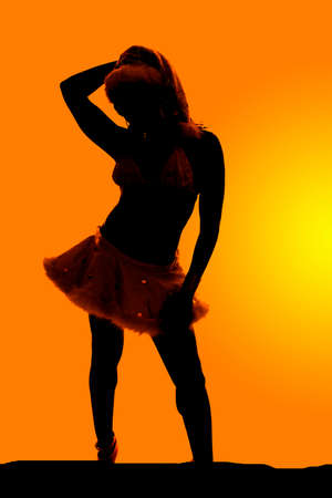 A silhouette of a woman in her skirt and hat.の写真素材