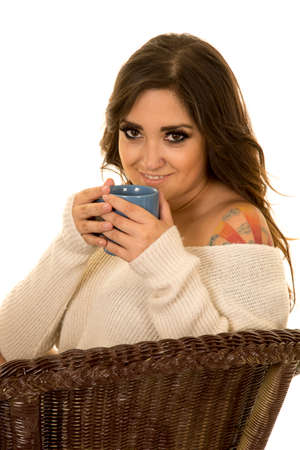 a woman in her sweater, sipping on her drink.の写真素材