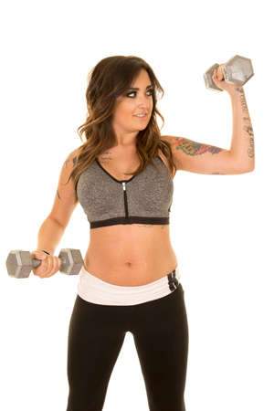 a woman with a smile on her face, working out with her weights.の写真素材