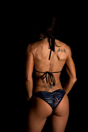 a woman in her swim wear with a tattoo on her shoulder and back.の写真素材
