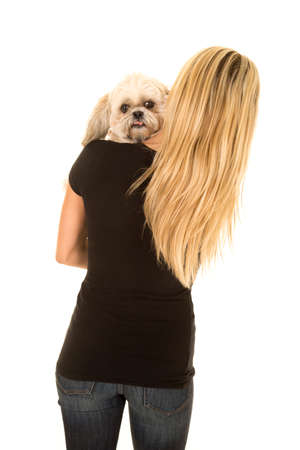 a woman with her puppy over her shoulder looking.の写真素材