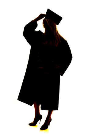 a silhouette of a woman in her graduation cap and gown.の写真素材