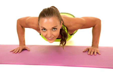 A woman doing a push up looking to the front.の写真素材