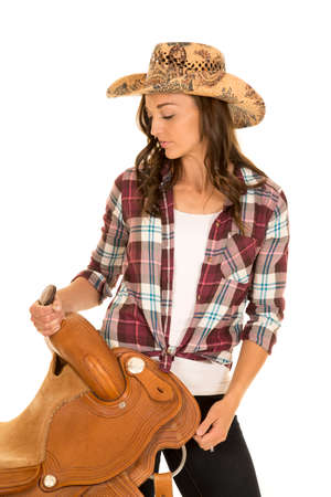 A cowgirl looking down at her saddle with a peaceful expression.の写真素材