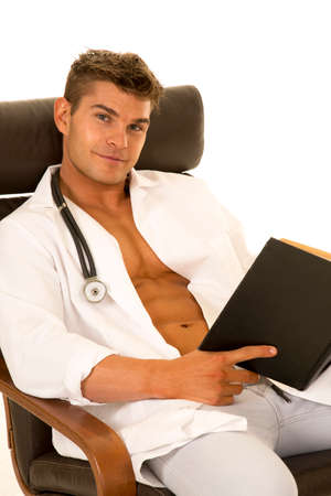 A Doctor with open jacket sitting and relaxing with a good bookの写真素材