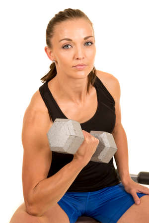 a woman doing a an isolation curl with a serious expression.の写真素材