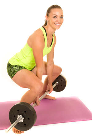 a woman doing a deadlift with a smile on her face.の写真素材