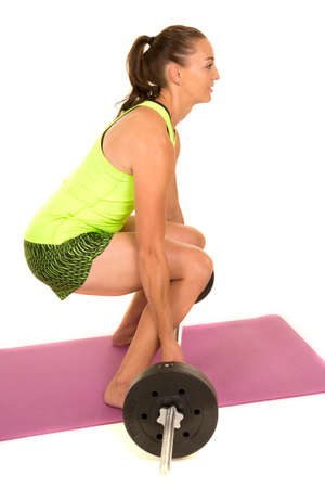 A woman looking to the side, doing a deadlift.の写真素材