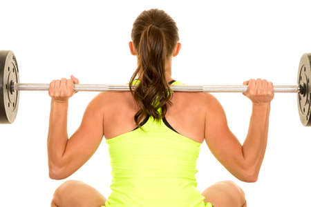 a woman doing a squat with a weighted bar across her back.の写真素材