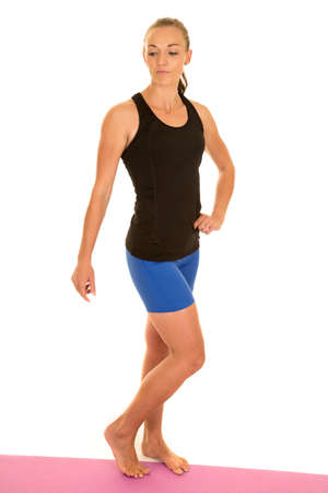 A woman in her fitness clothing posing and showing off her fit body.の写真素材