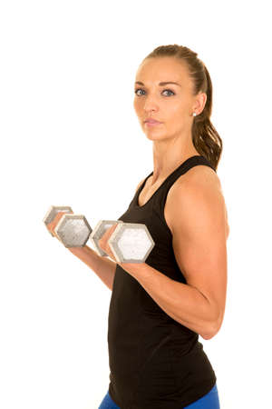 A woman working out with weights looking to the side.の写真素材