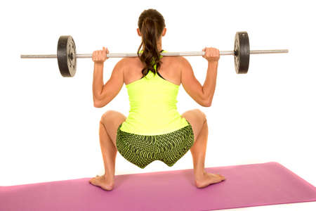 A woman doing a squat from the back with weights.の写真素材