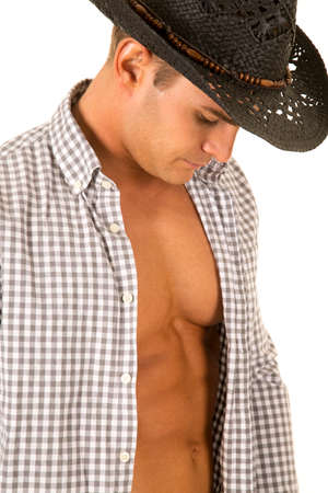 A cowboy with his chest showing, looking down.の写真素材