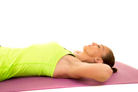 A woman taking a break from her crunches with her eyes closed.の写真素材