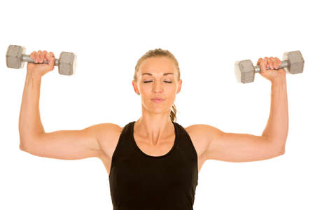 A woman with her eyes closed working out with her weightsの写真素材