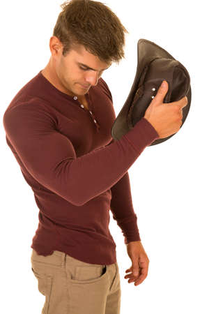 A cowboy getting ready to put his hat on his head.の写真素材
