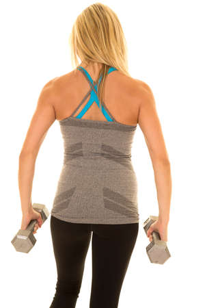 a woman working out with  her back to the camera with weights.の写真素材