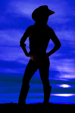 a silhouette of a cowgirl in the outdoors standing.の写真素材