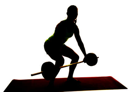 A silhouette of a woman doing a deadlift showing off her power.の写真素材