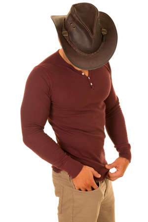 A cowboy looking down in his fit tight shirt.の写真素材