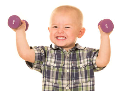 a young boy with a big smile, lifting weights.の写真素材