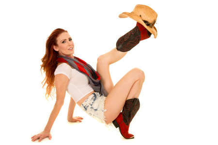 A cowgirl being playful with her western hat on her western boot.の写真素材