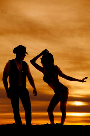 A silhouette of a woman leaning into her cowboy.の写真素材