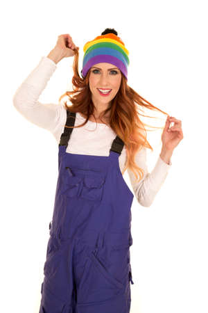 a woman with her purple coveralls playing with her hair while wearing her colorful beanie.の写真素材