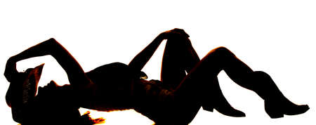 A silhouette of a woman laying back arching her back.の写真素材