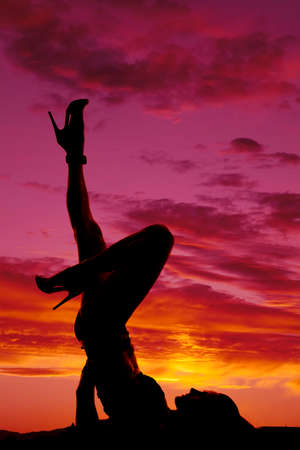 A woman laying back on her back with her legs kicked up.の写真素材