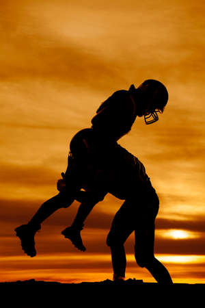 A football player making a hard hit on another player.の写真素材