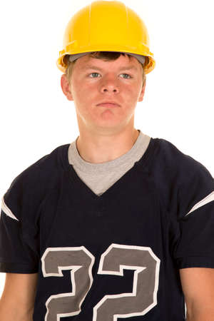 A teen football player in his jersey with a hard hat on his headの写真素材