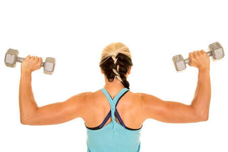 a back of a woman working out her shoulders with weights.の写真素材
