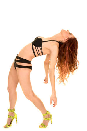 A woman in her black bikini leaning back with her arms out.の写真素材