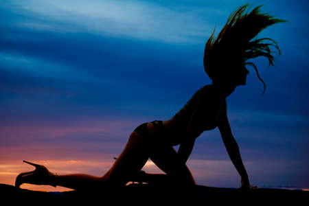 a silhouette of a woman flipping her hair on the ground.の写真素材
