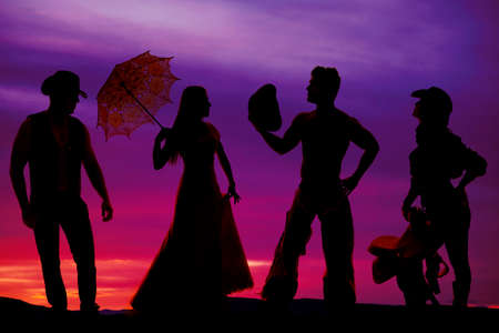 A silhouette of a group of cowboys and their ladies.の写真素材