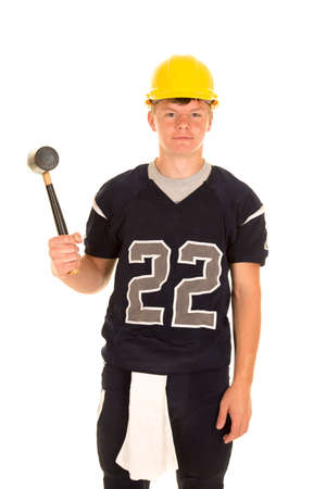 A teen football player in his jersey with a hard hat on his headの写真素材