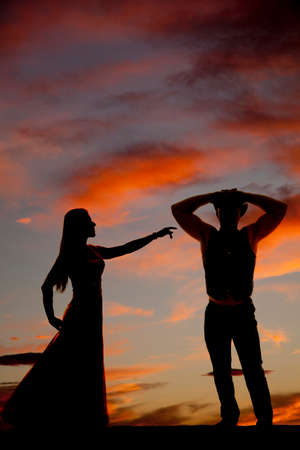 a silhouette of a woman reaching out to her cowboy.の写真素材