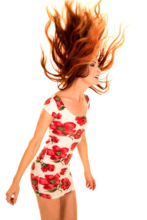 a woman flipping her fire red hair, in her dress.の写真素材