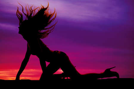a silhouette of a woman crawling flipping her hairの写真素材