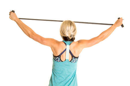 A woman's back in her fitness clothing using her muscles to stretch it.の写真素材